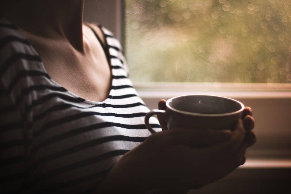 woman holding cup of coffee